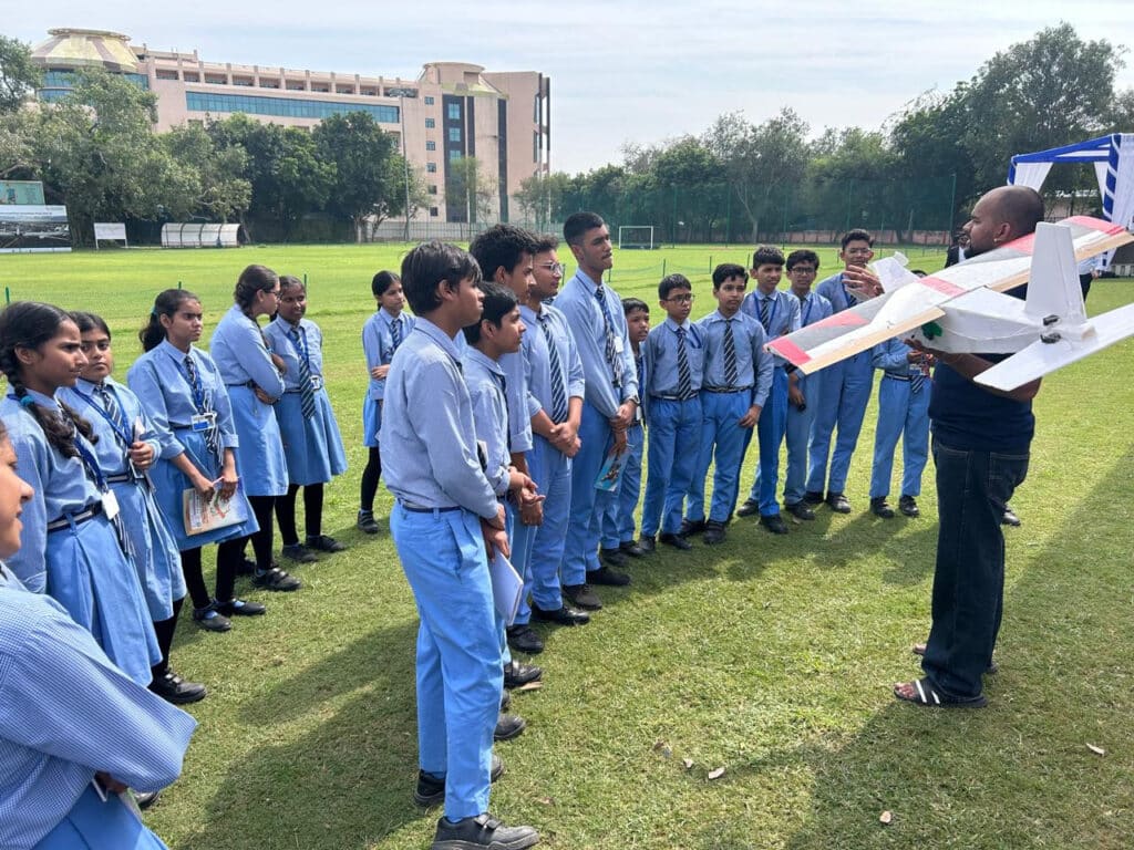 Coach explaining a remote-controlled model aircraft to Sulabh Public School students at IIT Delhi