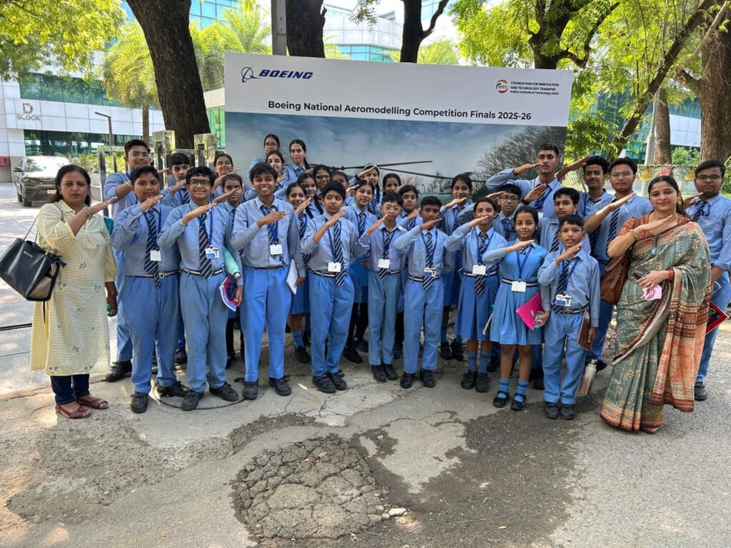 31 Sulabh Public School students posing with aircraft-wing hand gestures at the Boeing aeromodelling finals, IIT Delhi